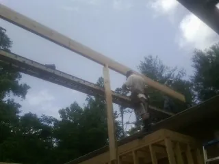 Carpenter setting a ridge beam over a new addition frame — Ice Dam Removal by Roofing Brothers in Dillonvale