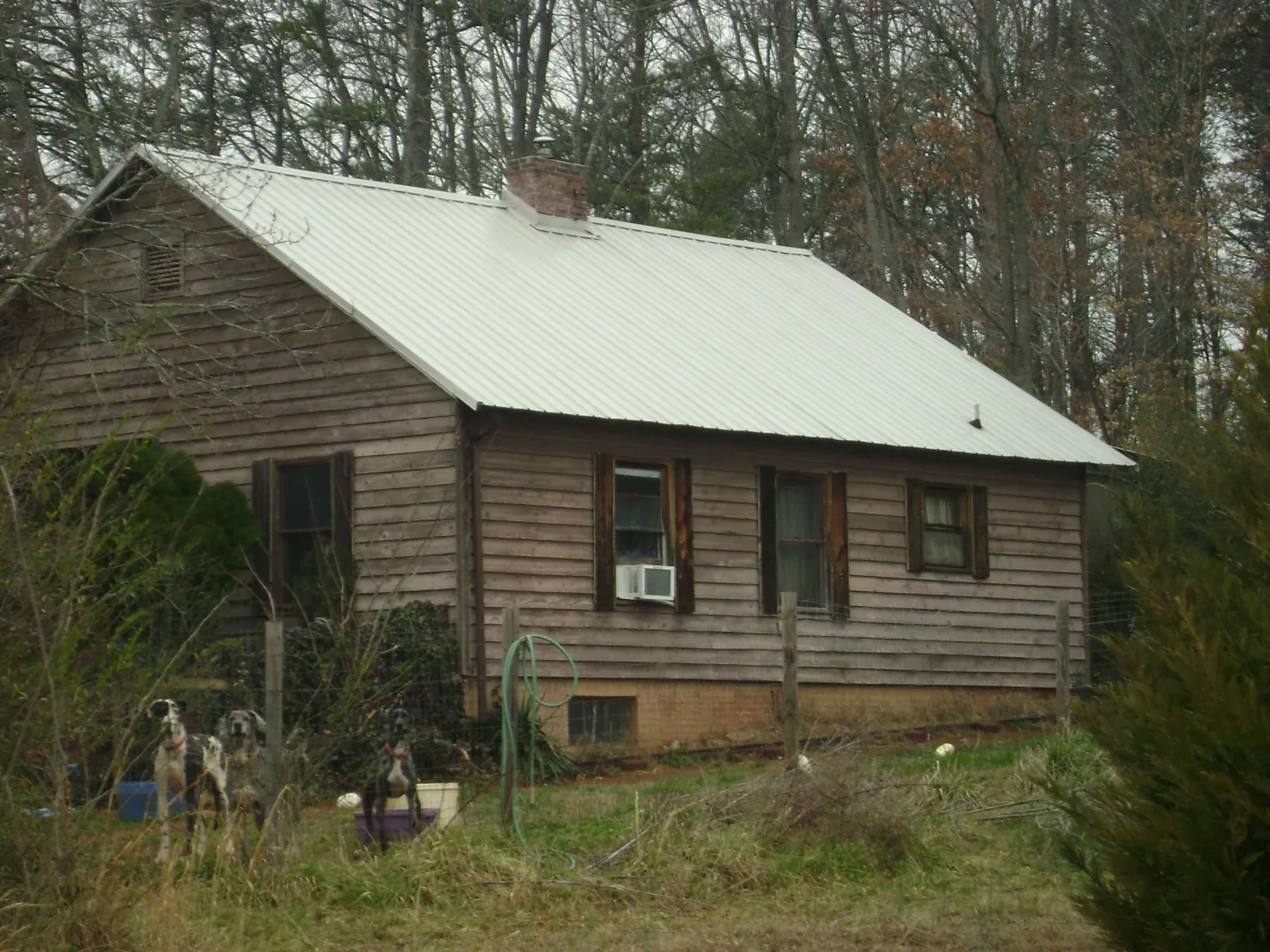 White metal roof on an old wood sided farmhouse, from a Metal Roof Installation job in Dillonvale